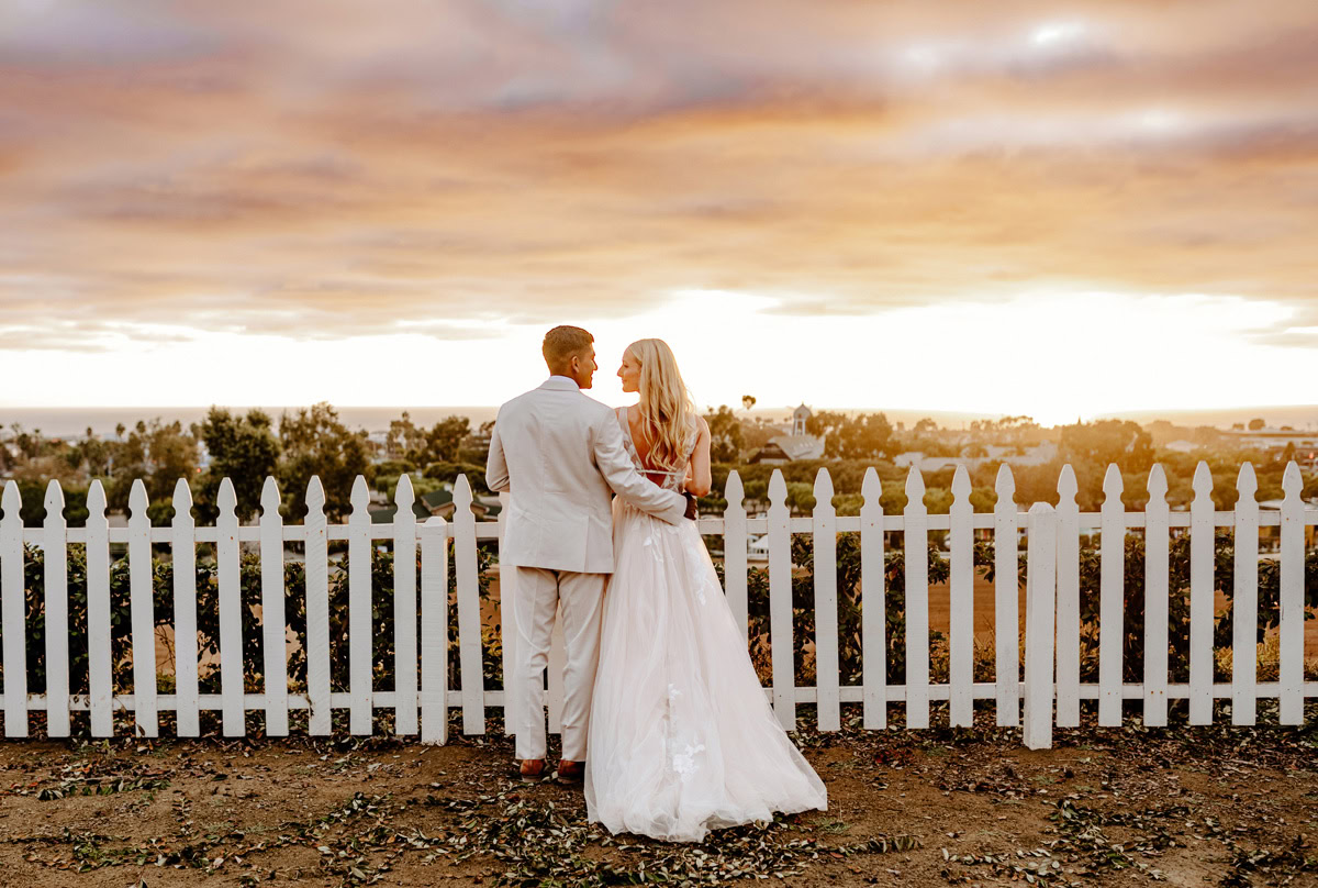 Bride and groom couple looking toward the horizon at a beautiful sunset at The Flower Fields Carlsbad.